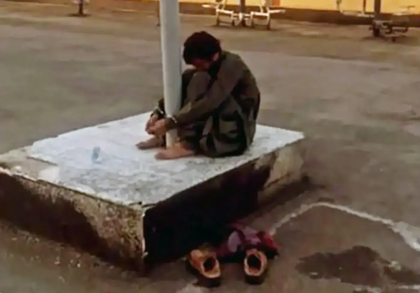 Khodanur Lojei handcuffed to a post by Iranian security forces, July 2022. A cup of water was placed deliberately out of his reach.